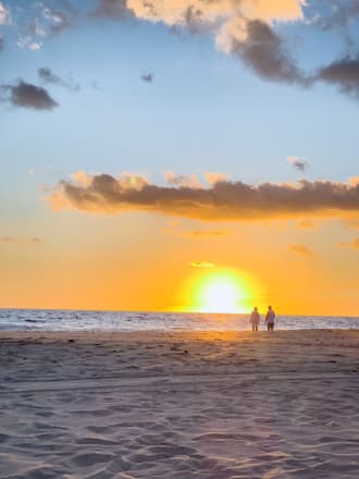 Walking together on the beach at sunset